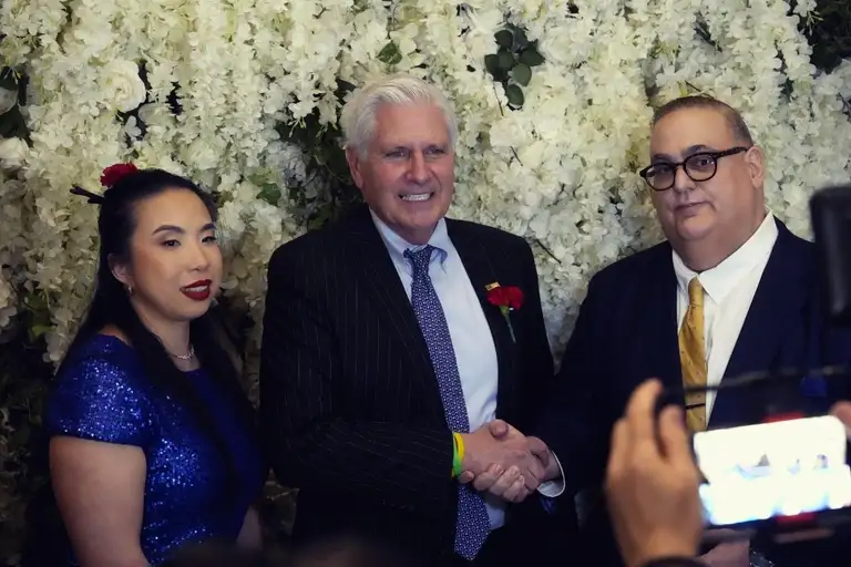 Guests greet each other in front of a flower wall at the Brooklyn GOP Lincoln Day Gala